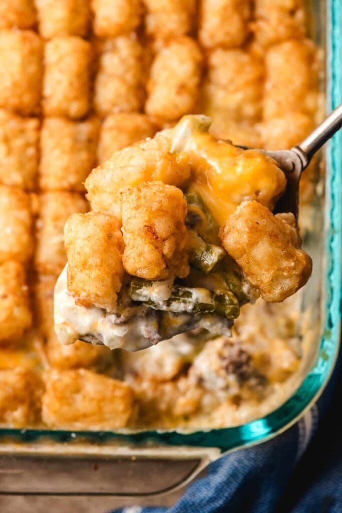 Close-up of tater tot casserole on a serving spoon.