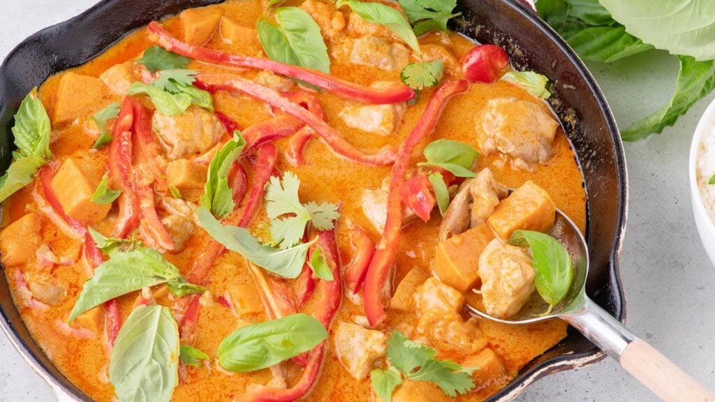 Thai red curry chicken in a skillet.