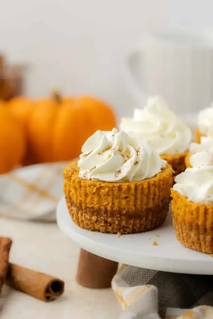 White chocolate pumpkin cheesecakes with Golden Oreo crust on a dessert stand.