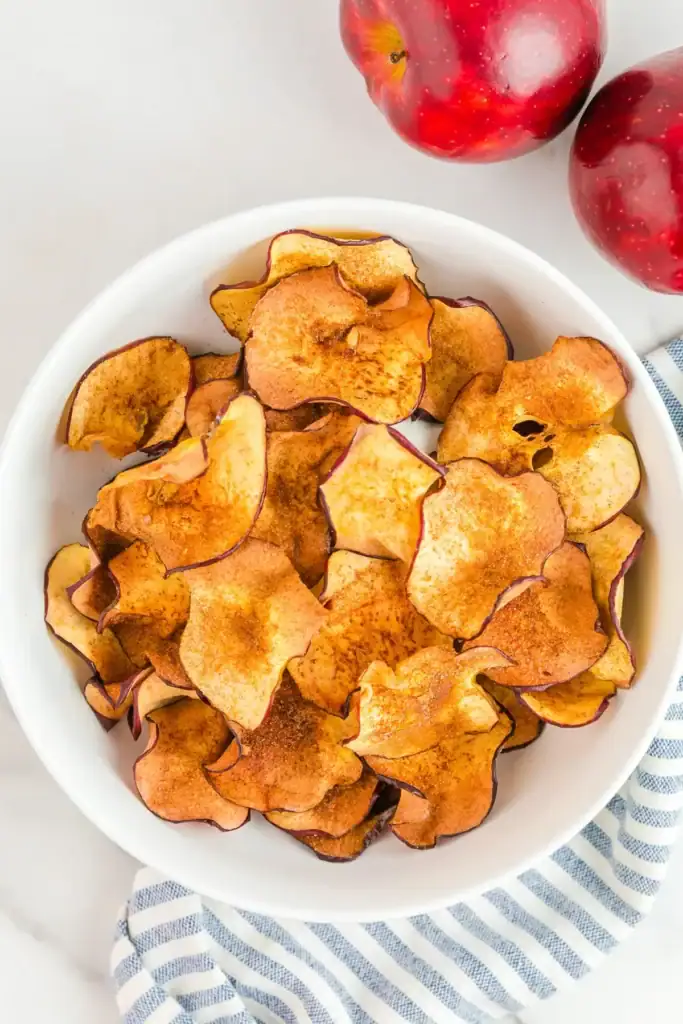Air fryer apple chips in a bowl.
