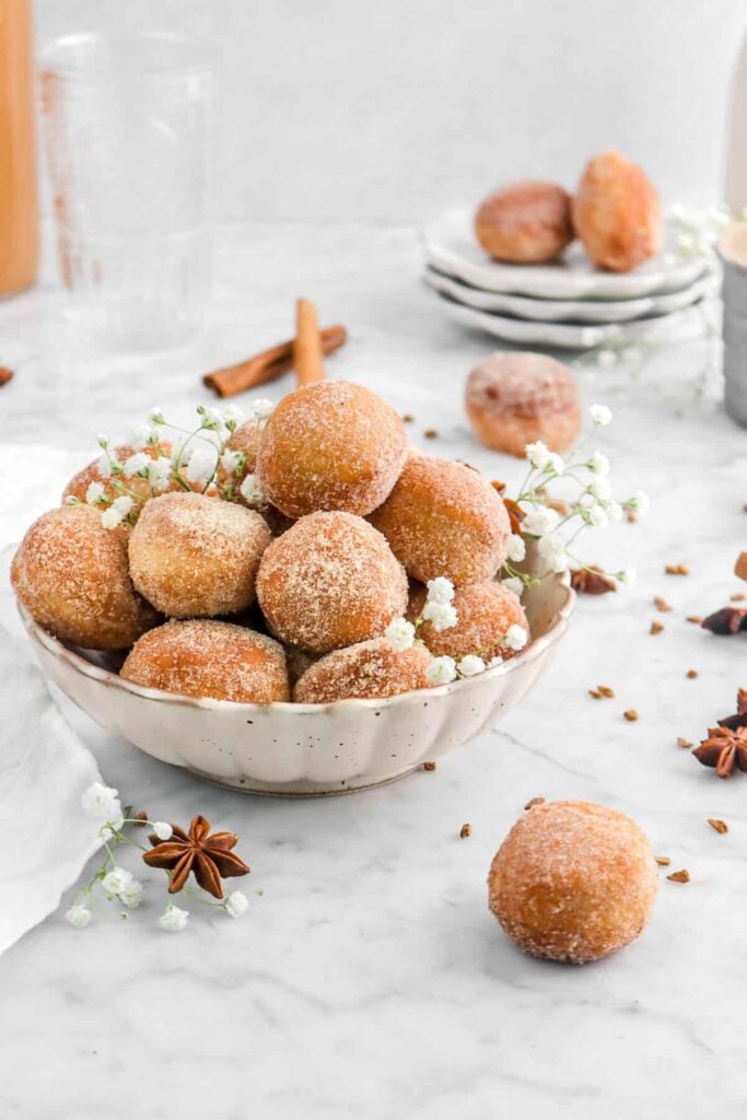 Apple cider donut holes with spiced sugar in a bowl.
