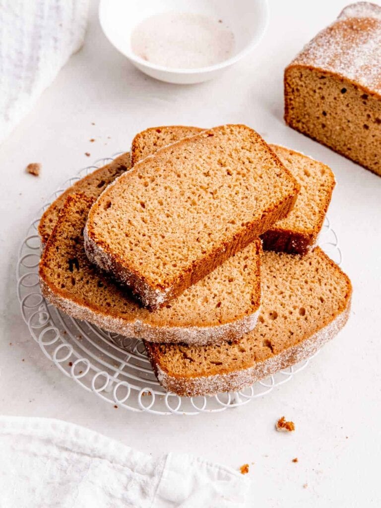 Apple cider donut loaf cake on a cooling rack.