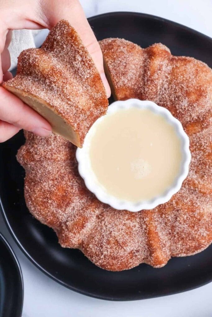 Apple cider doughnut cake with glaze on a plate.