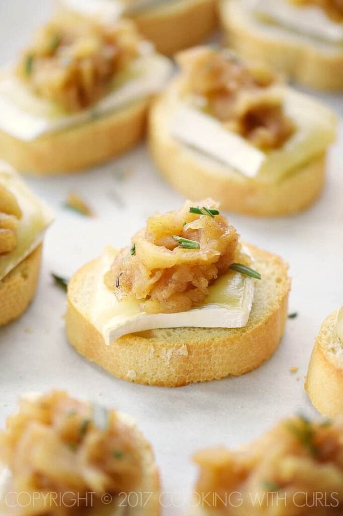 Apple compote and brie crostini on parchment paper.