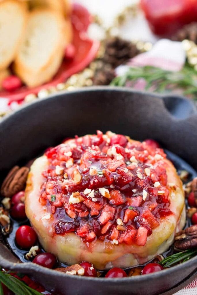 Apple cranberry baked brie in a skillet.