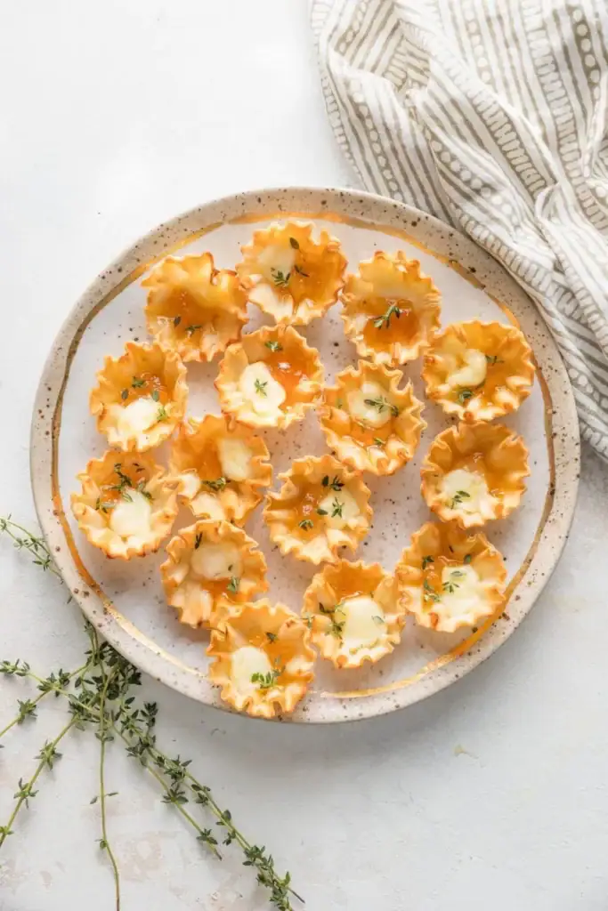 Apricot brie bites on a white plate.