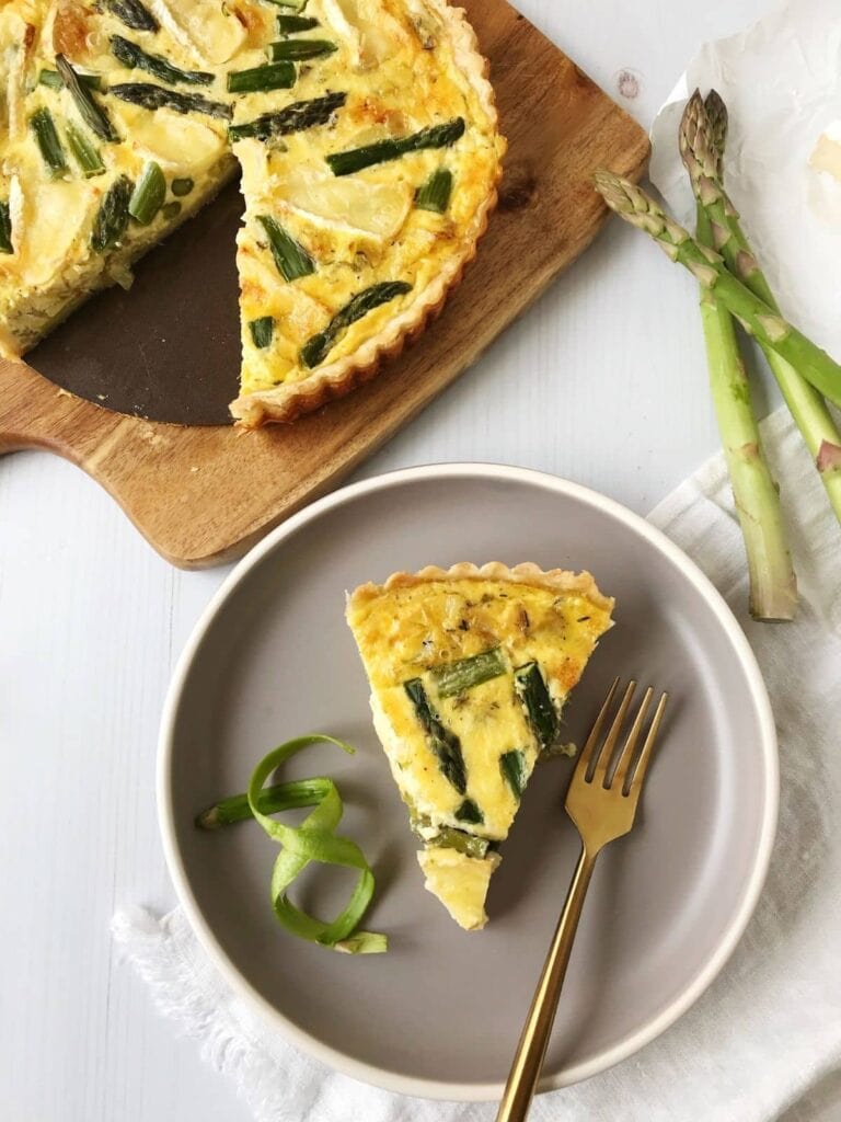 Asparagus, leek and brie quiche on a plate.