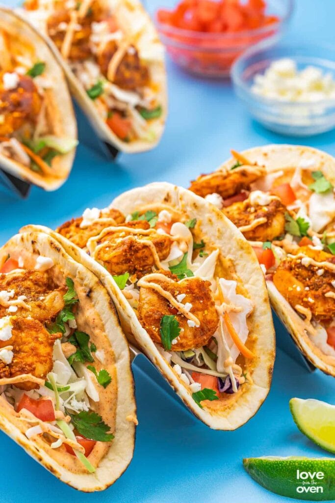 Baja shrimp tacos on a blue surface.