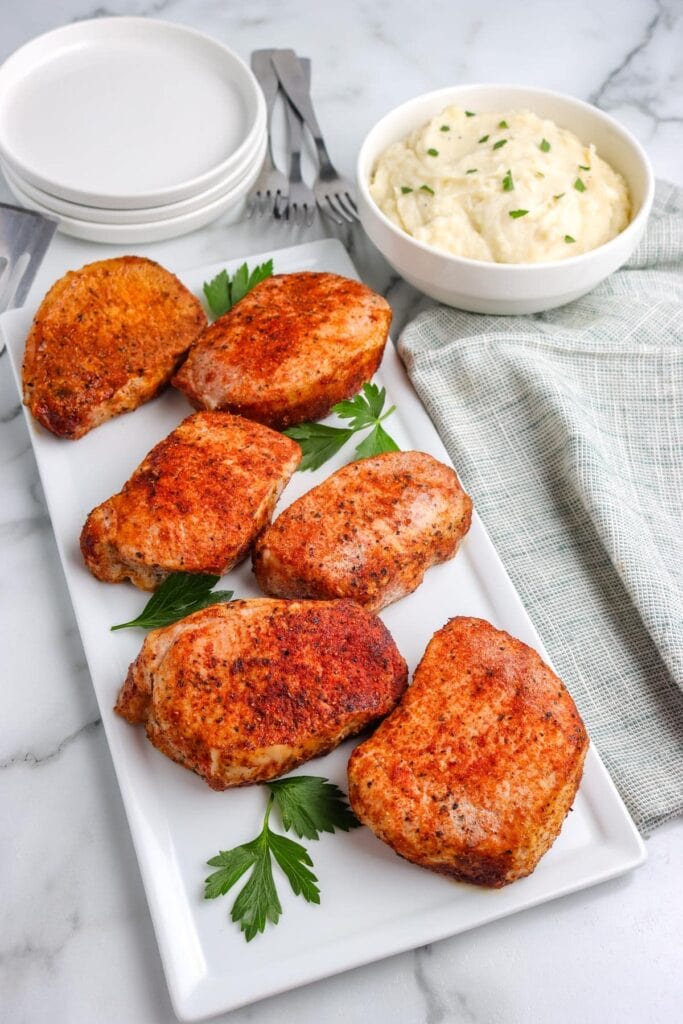Baked boneless pork chops served on a plate.