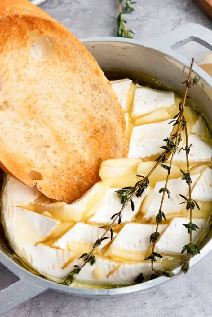 Baked brie with honey and garlic in a pot.