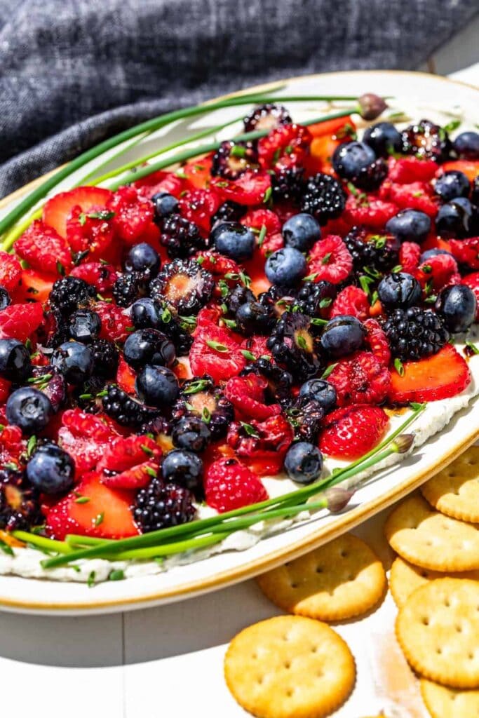 Boursin dip topped with fresh berries on a plate.