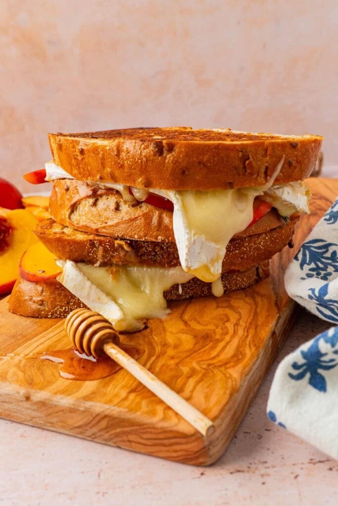 Brie grilled cheese sandwich on a wooden board.