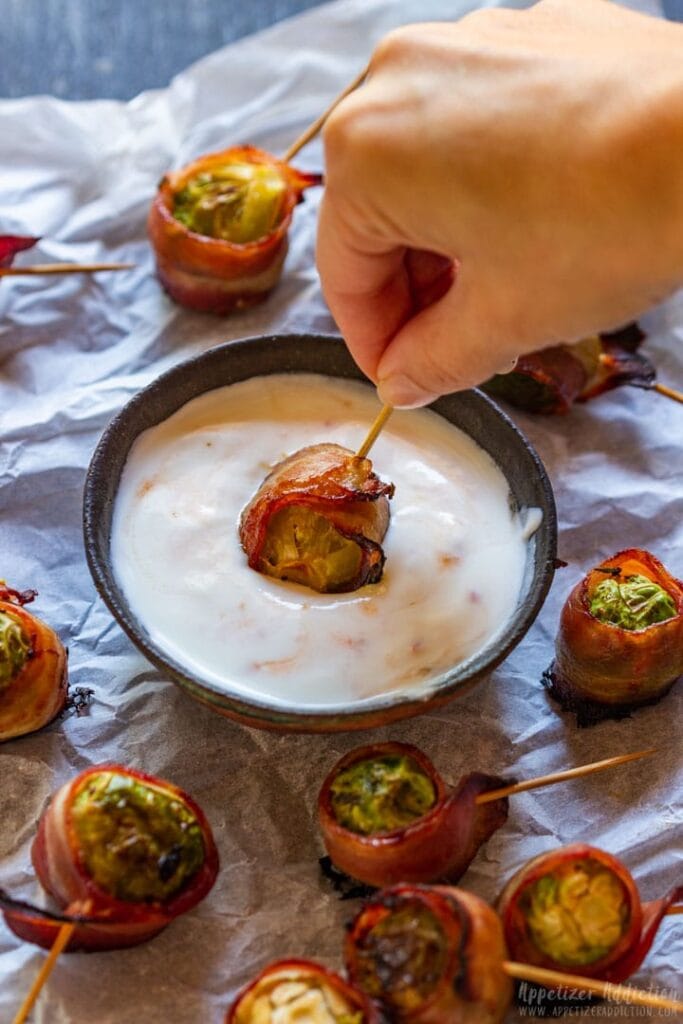 Brussels sprouts wrapped in bacon dipped in sauce.