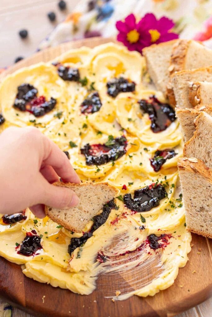 Butter board with berry jam served with bread.
