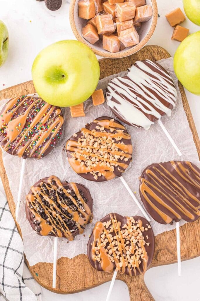 Caramel apple slices on a wooden board.