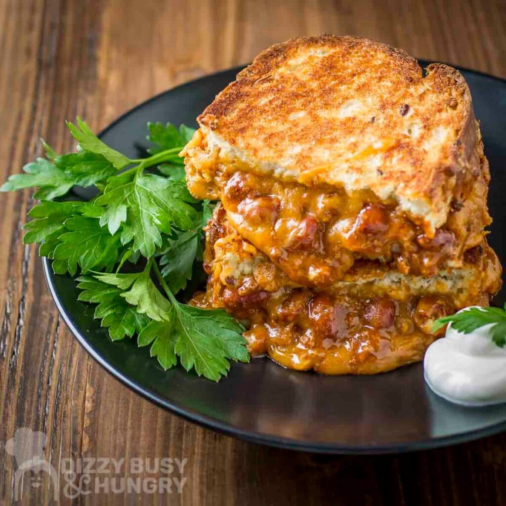Chili grilled cheese sandwich served on a plate.
