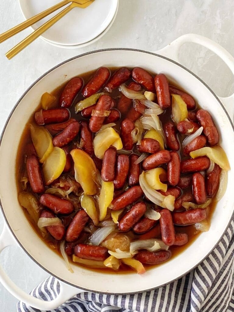Cocktail franks with apples and onions in a pot.