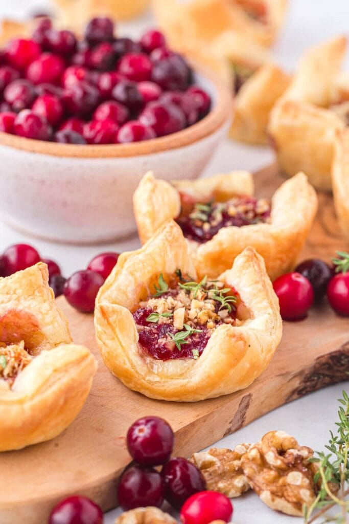 Cranberry brie bites on a wooden board.