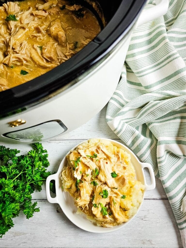 Crockpot chicken and gravy served over mashed potatoes.