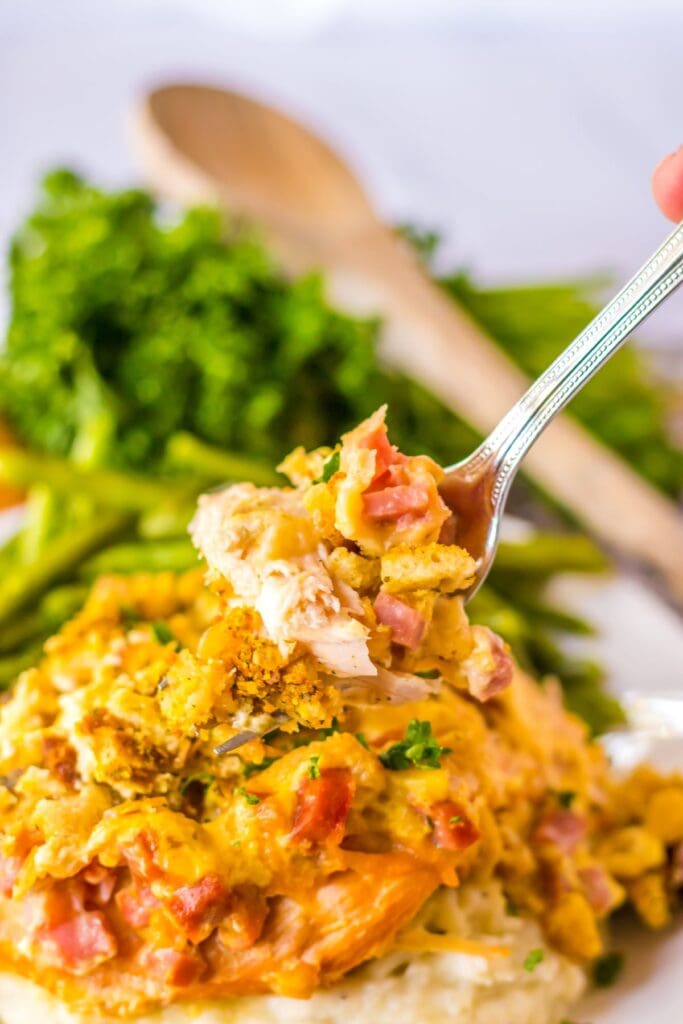 Close up of crockpot chicken Cordon Bleu on a serving spoon.
