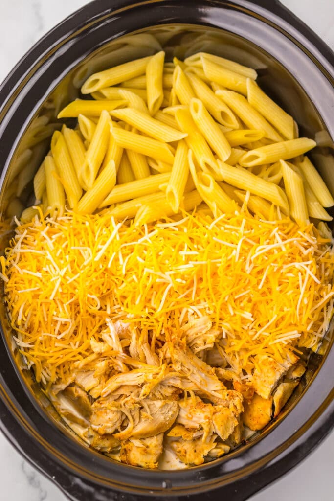 Pasta and cheese added to shredded chicken.