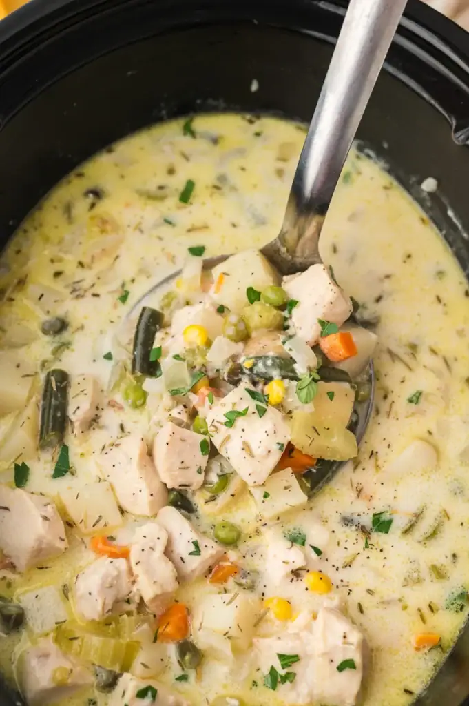 Chicken pot pie soup with biscuits in a slow cooker.