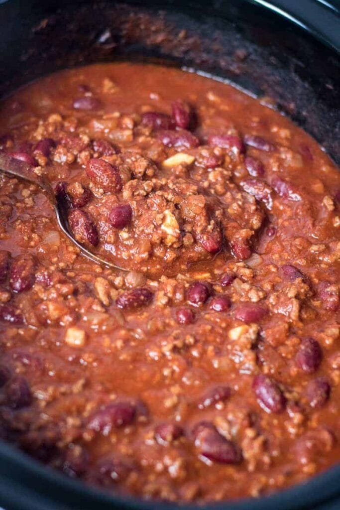 Crockpot chili with ground beef and kidney beans in a slow cooker.