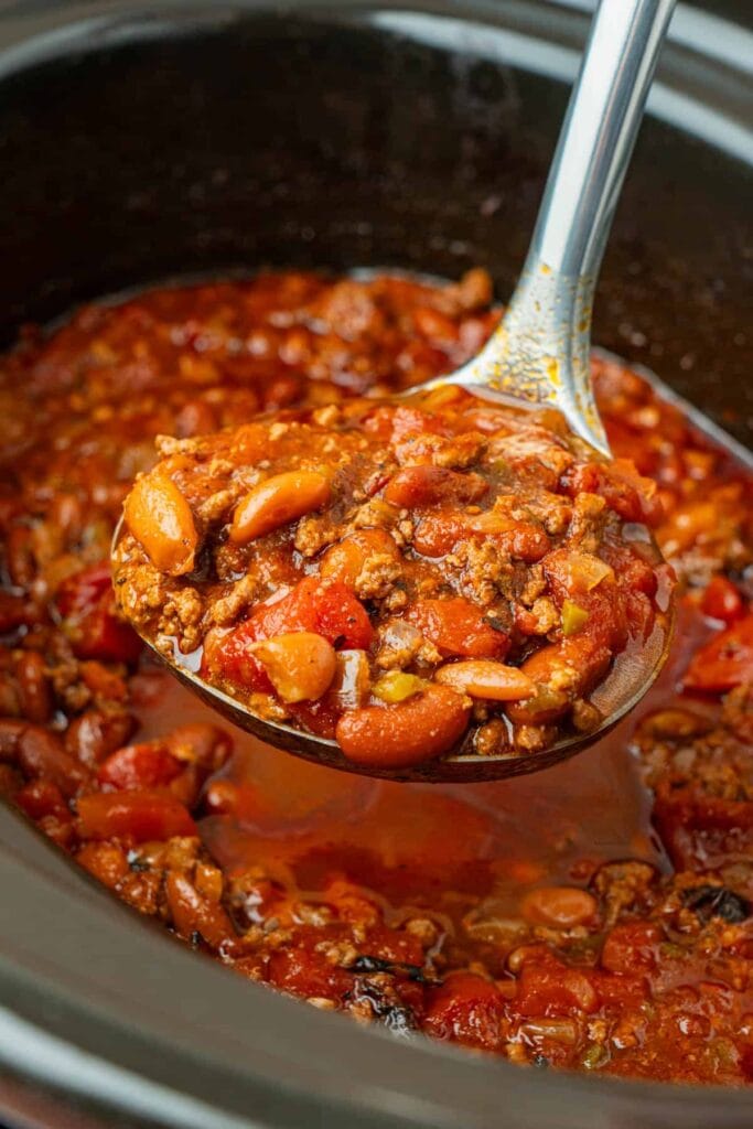 Close up of crockpot chili on a serving spoon.