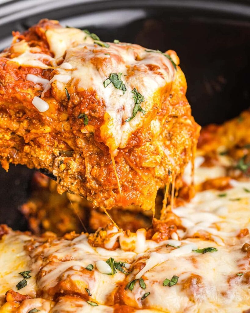 Close-up of crockpot lasagna on a spatula.