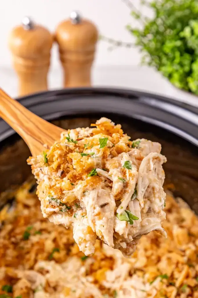 Close up of Ritz cracker chicken casserole on a wooden serving spoon.