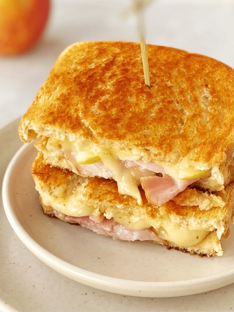 Ham, apple and brie panini on a plate.