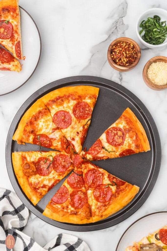 Homemade pizza with pizza dough on a table.