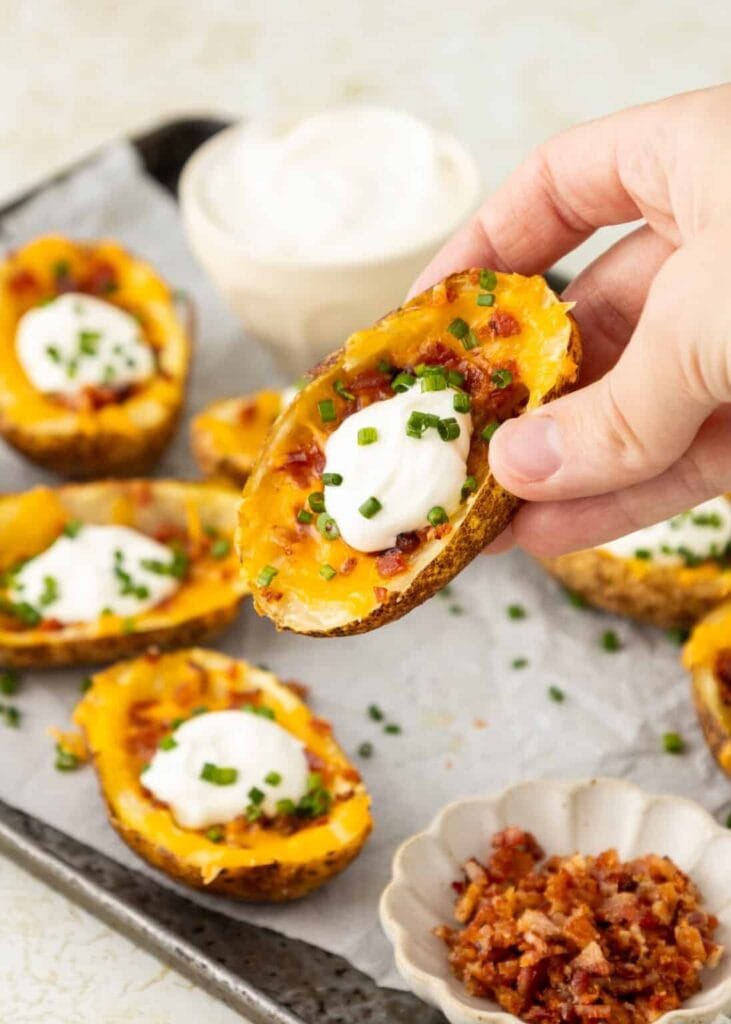 Loaded potato skins topped with cheese, bacon, and sour cream.