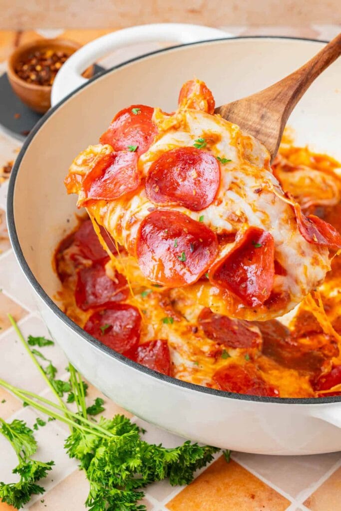 Close-up of low carb pizza chicken on a wooden spoon.
