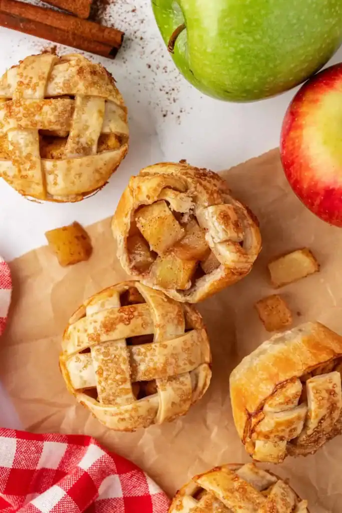 Mini apple pies on a wooden board.