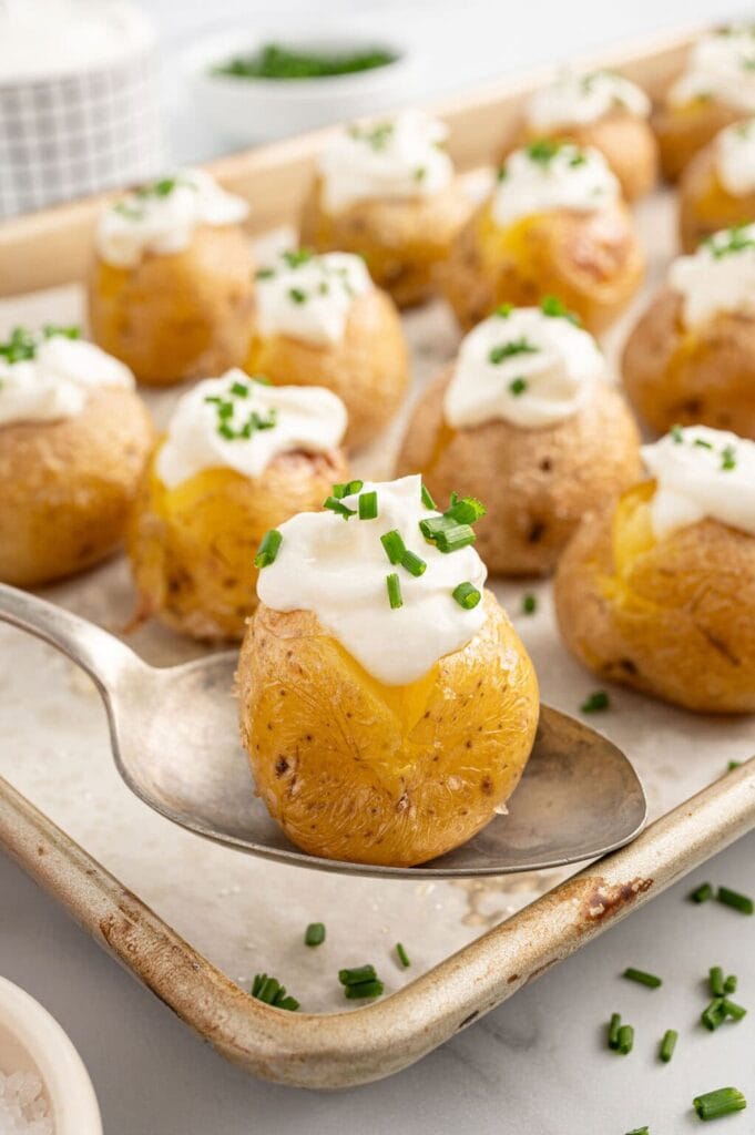 Close-up of mini baked potatoes on a spoon.