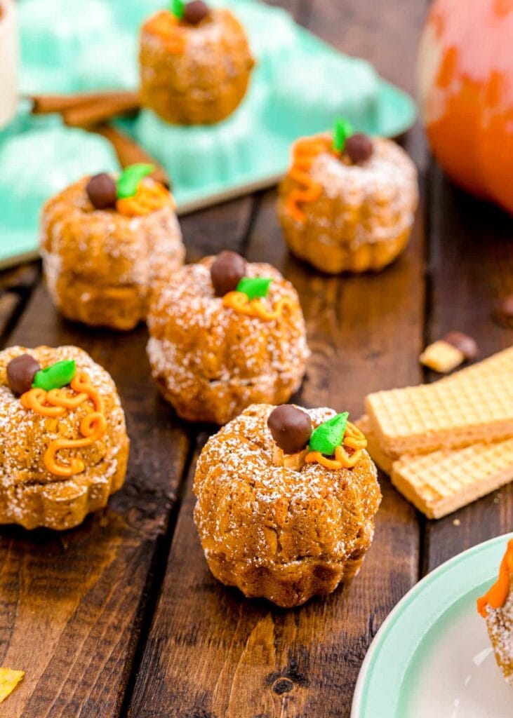 Mini pumpkin Bundt cakes on a wooden table.