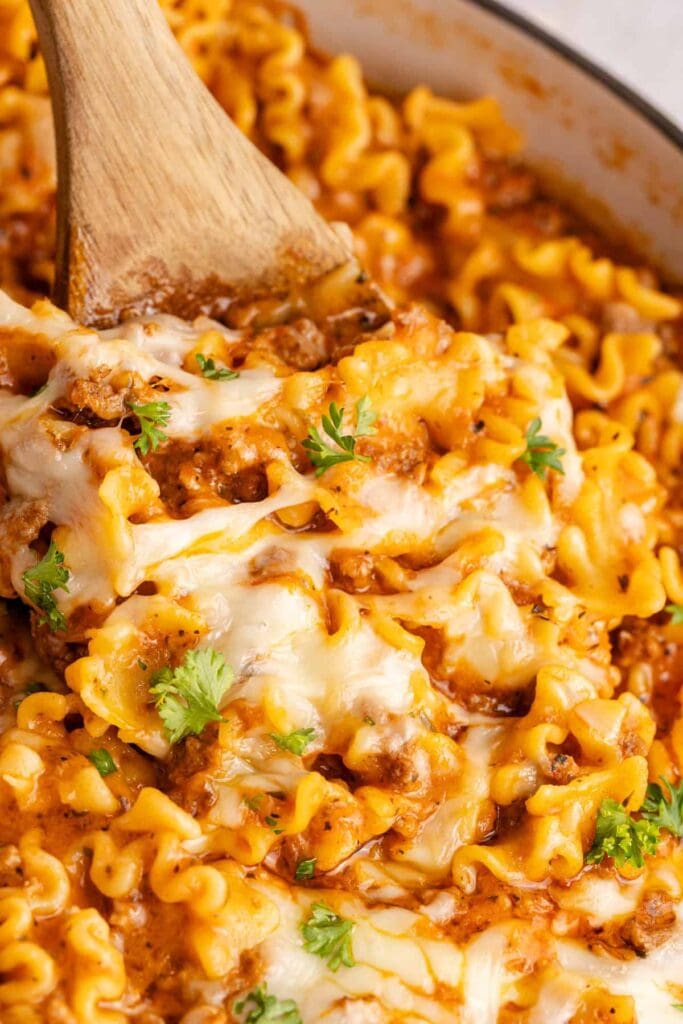 One pan lazy lasagna with melted cheese and ground beef in a skillet.