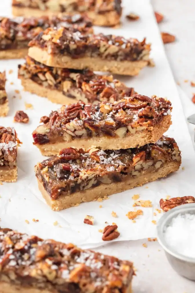Pecan pie cookie bars on parchment paper.
