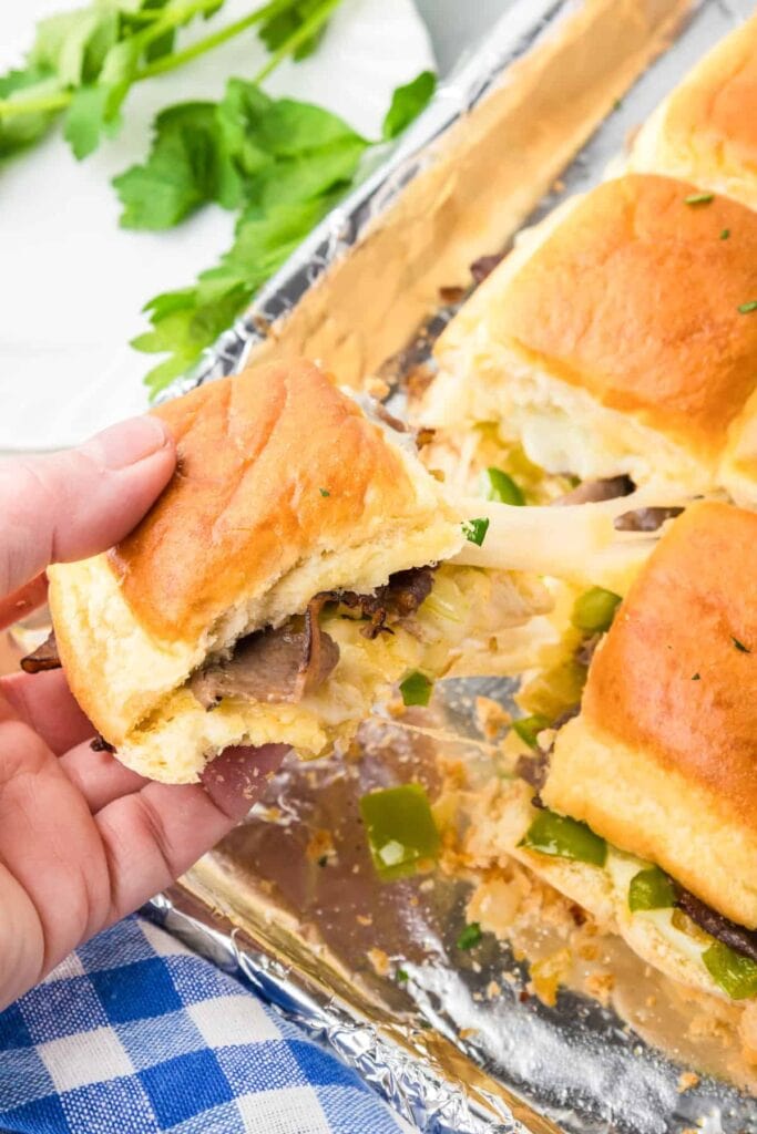 Philly cheesesteak sliders on a baking sheet.