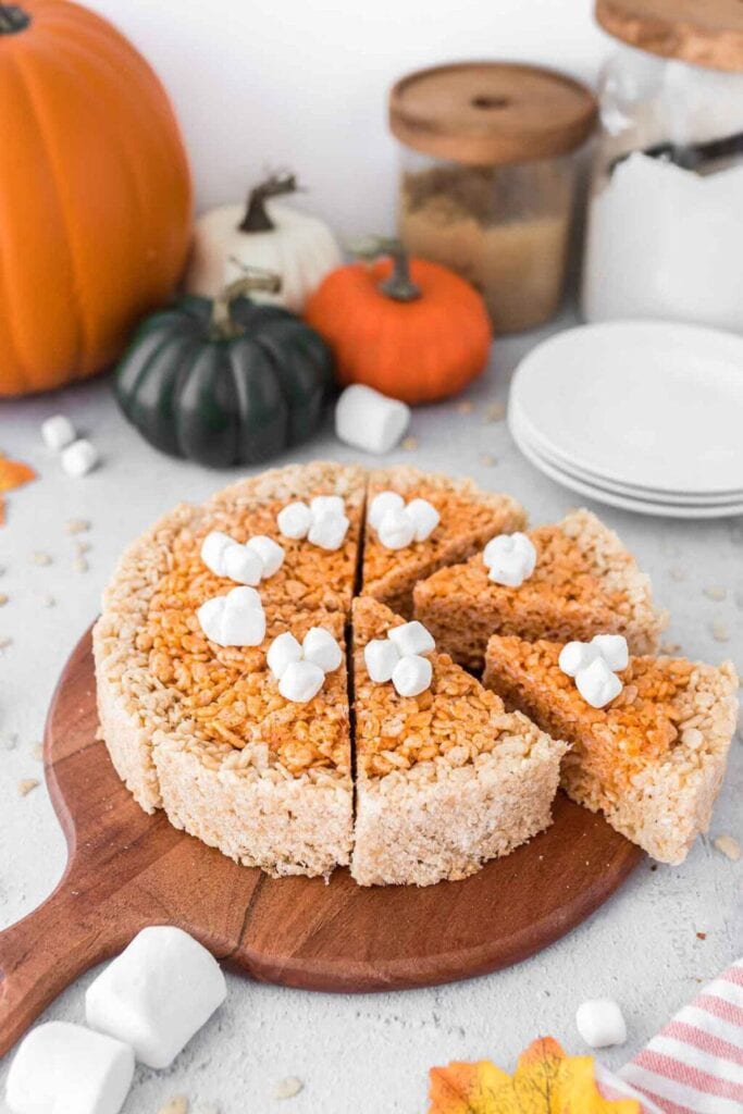 Pumpkin pie rice krispie treats on a wooden board.