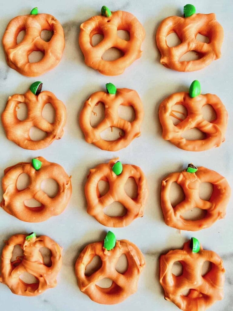 Pumpkin pretzels on parchment paper.