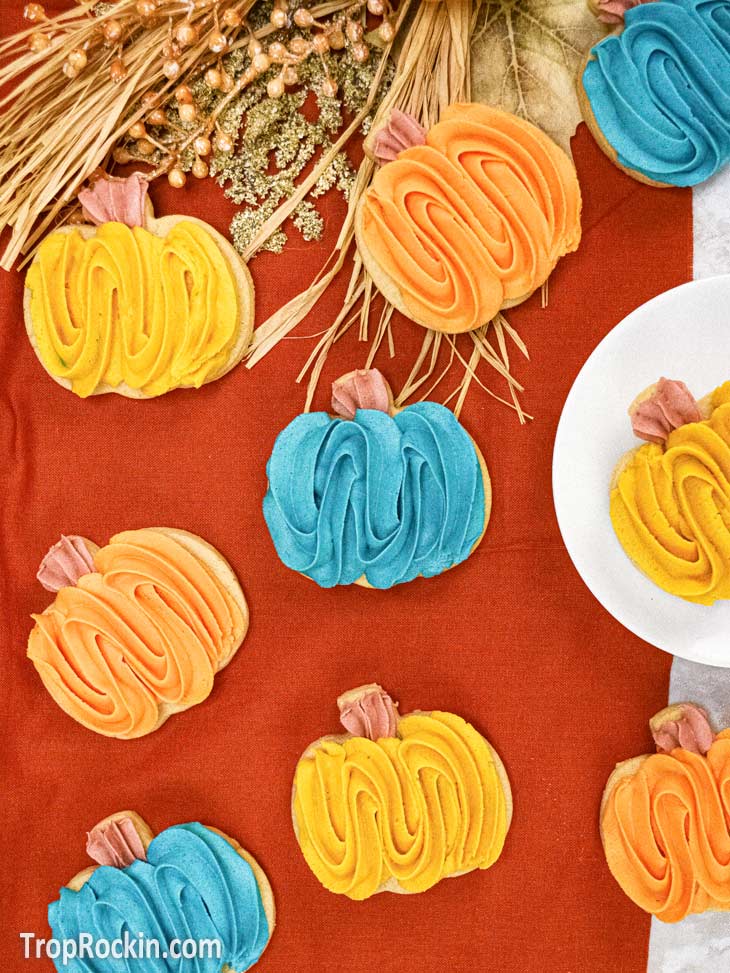 Pumpkin spice sugar cookies decorated with colorful pumpkin-shaped frosting.