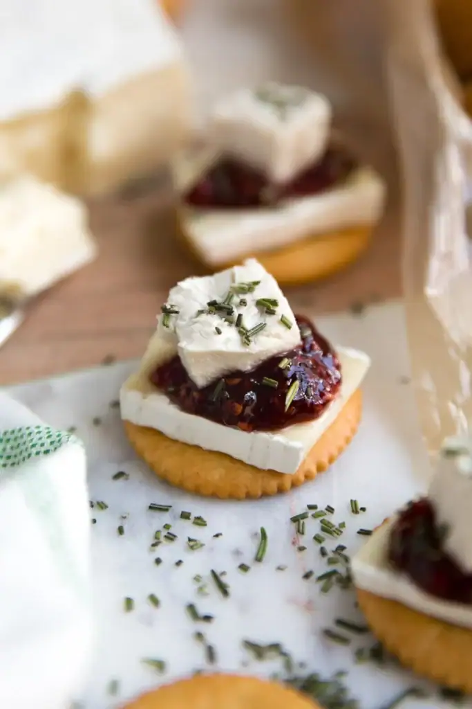 Close-up of Ritz cracker, brie and jam bites.