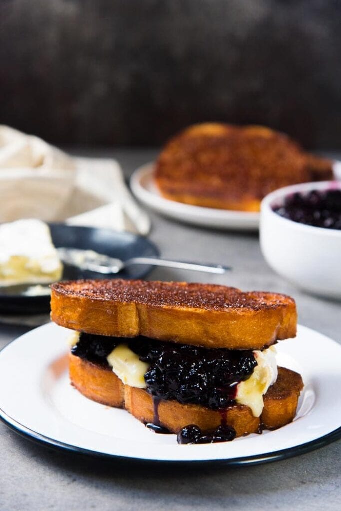 Roasted blueberries and brie with cinnamon toast on a plate.