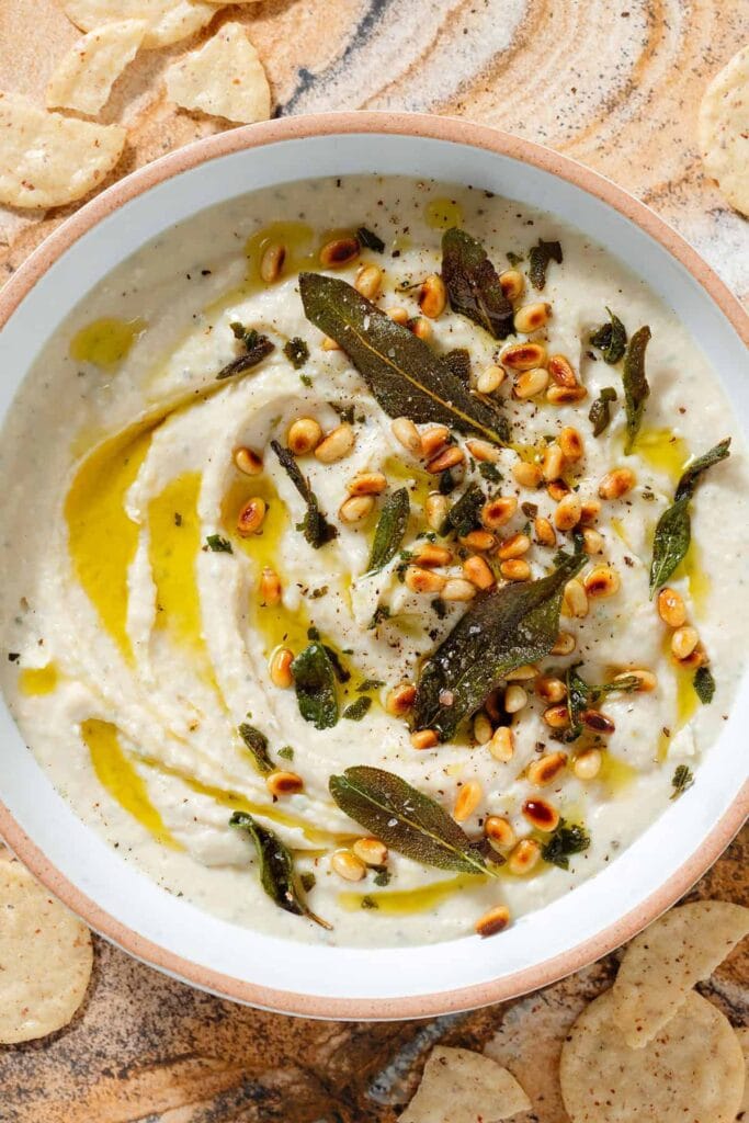 Roasted garlic white bean dip with sage in a bowl.