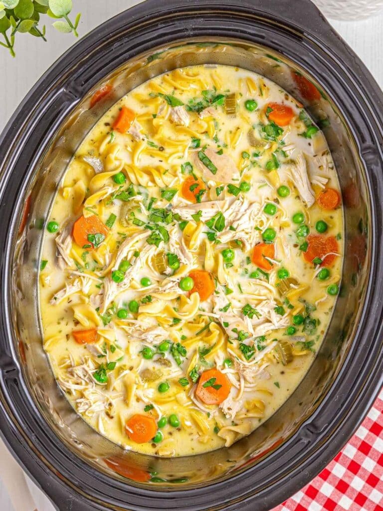 Creamy chicken noodle soup in a slow cooker.