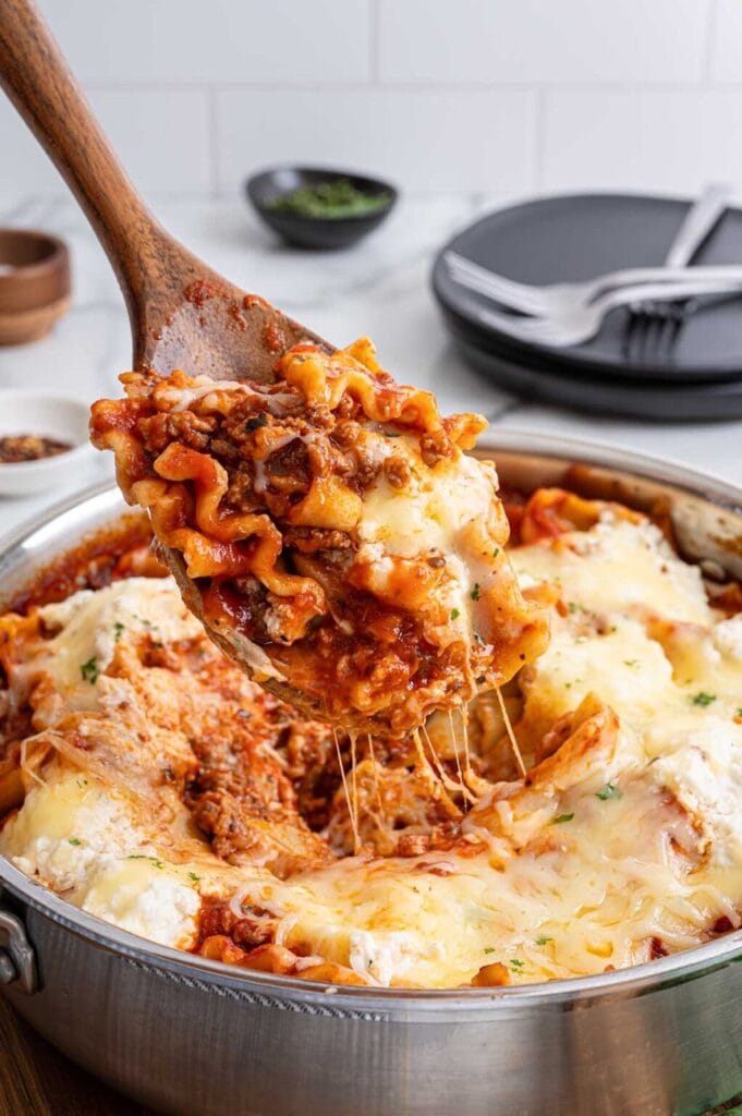 Close-up of skillet lasagna on a wooden spoon.