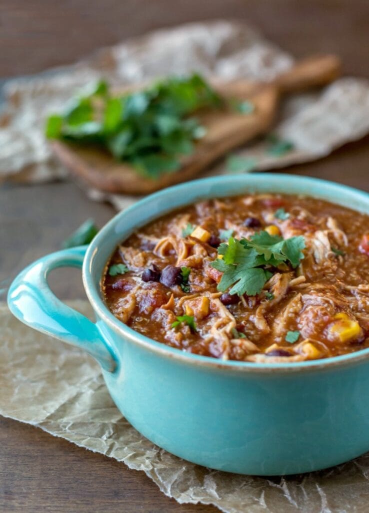 Slow cooker barbecue chicken quinoa chili served in a handled bowl.