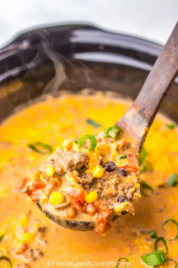 Slow cooker creamy taco soup on a wooden spoon.
